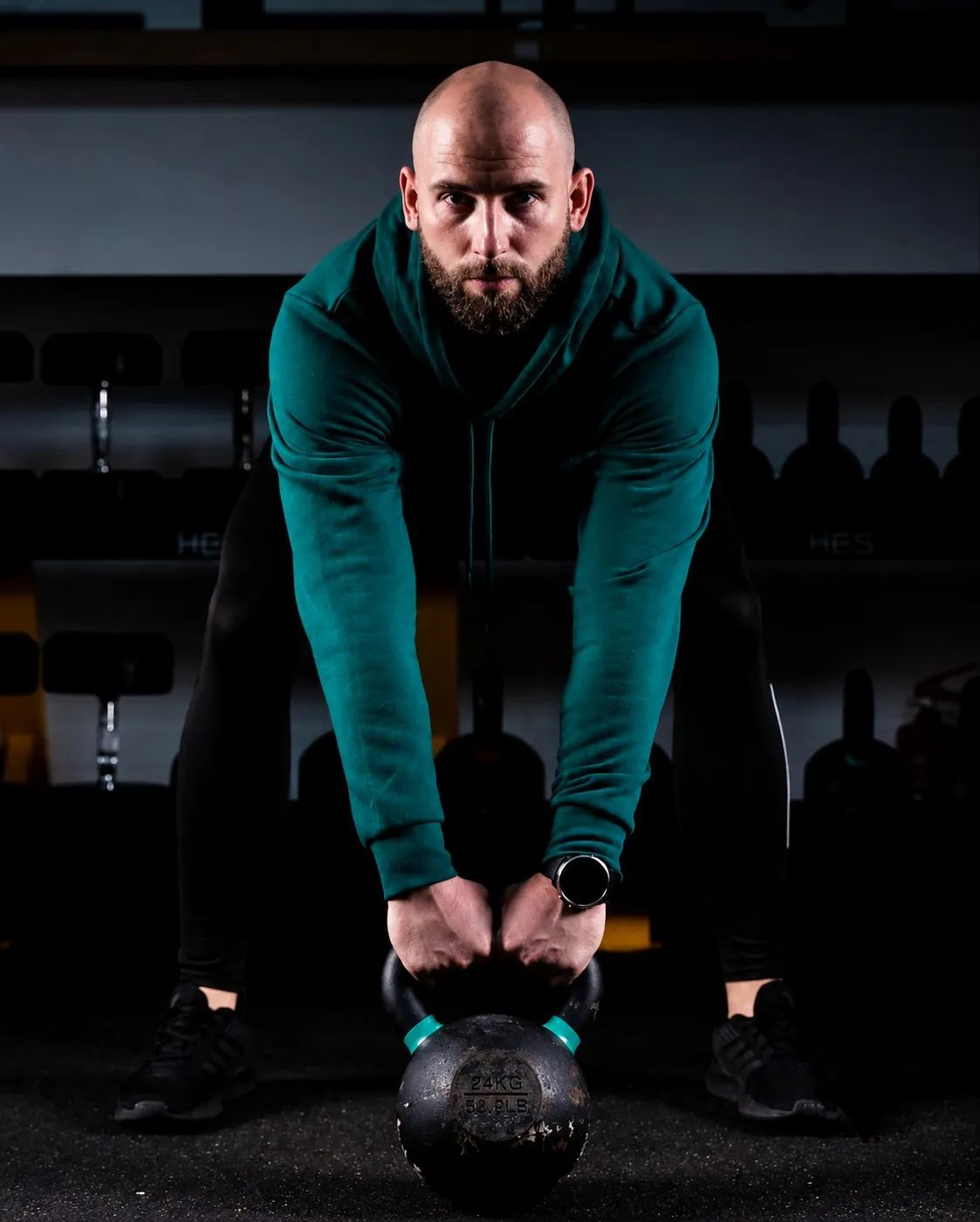 Wojciech Rokita w pozycji wyjściowej do unoszenia kettlebell 24 kg w studio siłowym